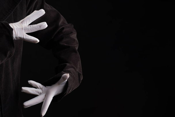 Hand gestures. Showman or magician illusionist in white gloves on a black background. - Foto, immagini