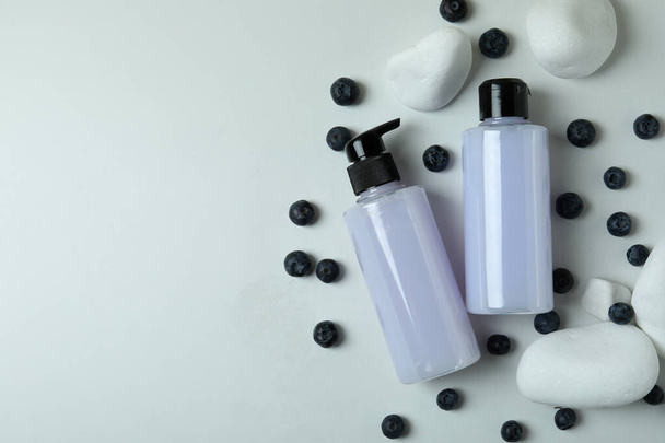 Shower gels, blueberry and stones on white background - Zdjęcie, obraz