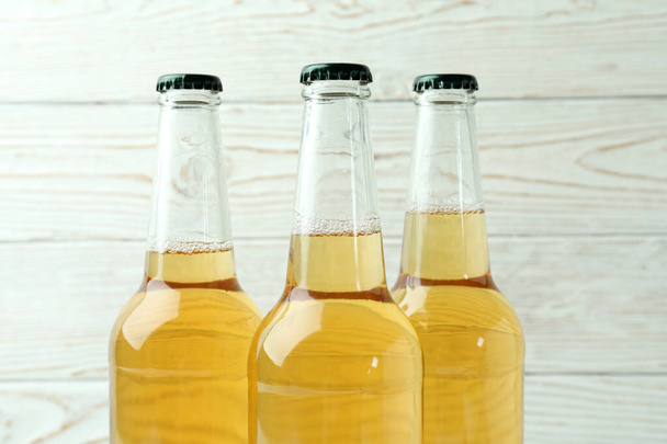Bottles of beer on white wooden background - Fotografie, Obrázek