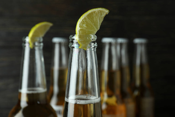 Beer with lime on wooden background, close up - Photo, Image