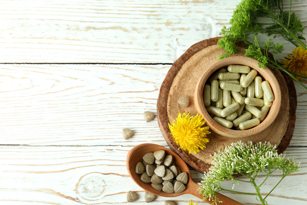 Concept de pilules de médecine à base de plantes sur table en bois blanc, espace pour le texte - Photo, image