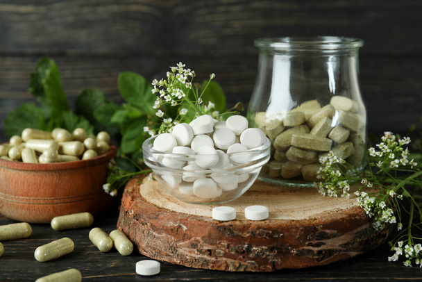 Concepto de píldoras de hierbas medicinales sobre fondo de madera - Foto, imagen