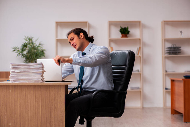 Joven empleado masculino infeliz con el trabajo excesivo - Foto, Imagen