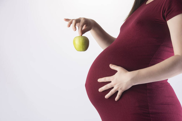 mulher grávida segurando uma maçã verde. Alimentação saudável. - Foto, Imagem