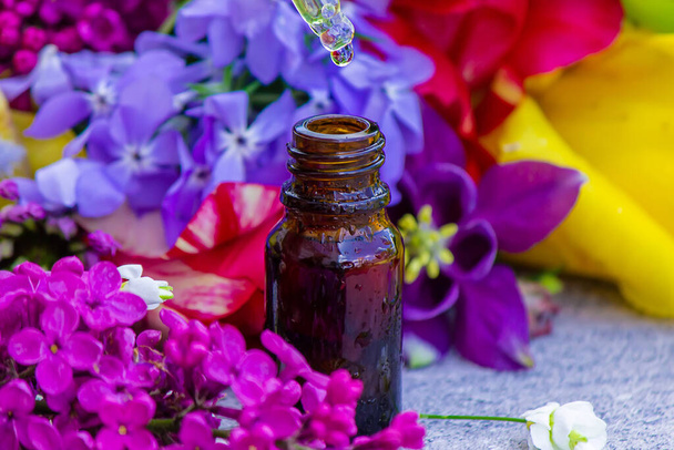 Flor Buzz Collection Flor aceite esencial. Aceite esencial de lila en una botella. Naturaleza. Enfoque selectivo - Foto, imagen