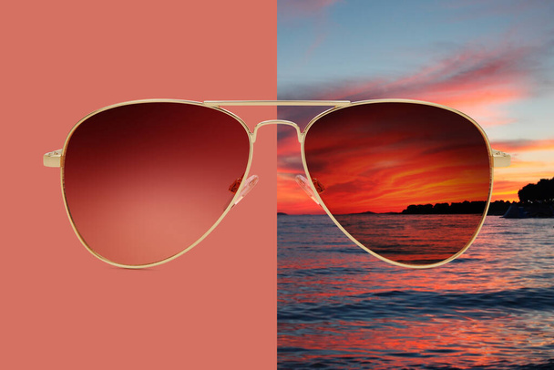 Fliegersonnenbrille isoliert auf rotem und sommerlichem Sonnenuntergang mit Meer und rotem Himmel, Konzept der polarisierten Schutzgläser - Foto, Bild