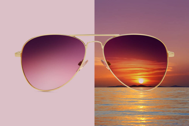 Pembe ve yaz günbatımında izole edilmiş güneş gözlükleri. Deniz ve kızıl gökyüzü, polarize koruyucu lensler kavramı. - Fotoğraf, Görsel