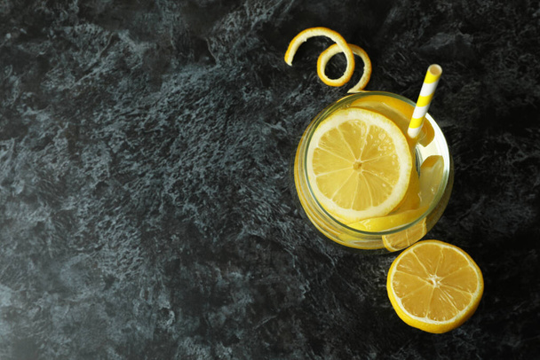Glass of lemonade on black smokey table - 写真・画像
