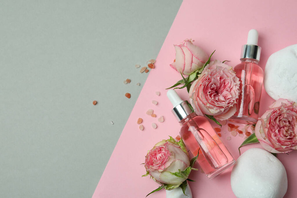 Concetto di cura della pelle con olio essenziale di rosa su sfondo bicolore - Foto, immagini