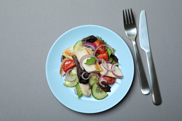 Concept of tasty eating with salad with grilled chicken on gray background - Fotoğraf, Görsel
