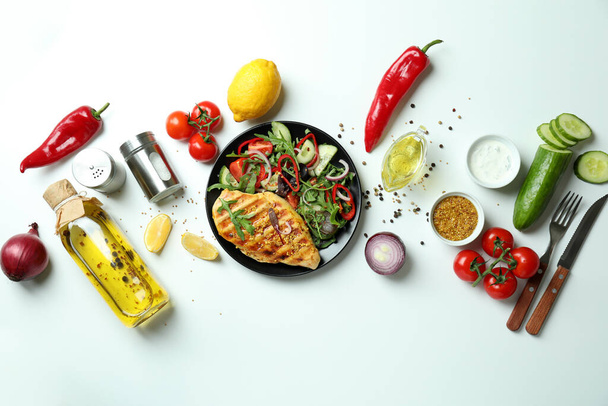 Concepto de sabroso comer con ensalada con pollo a la parrilla sobre fondo blanco - Foto, Imagen