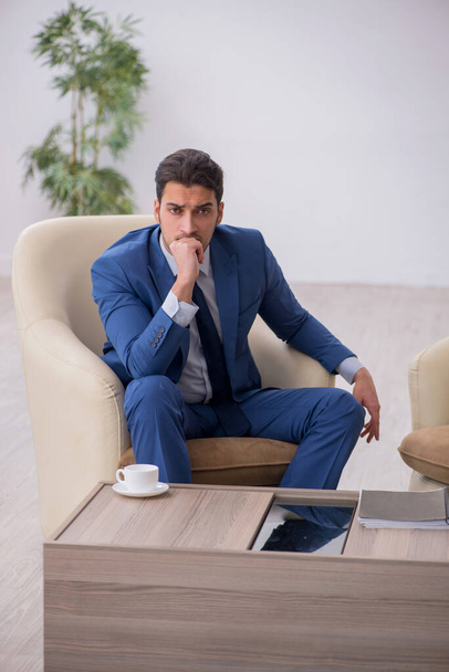 Jeune employé masculin en attente d'une réunion d'affaires - Photo, image