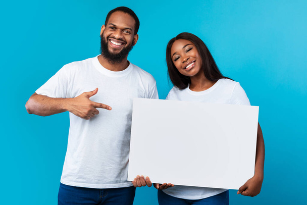 Happu black couple holding pointing at blank white advertising placard - Photo, Image