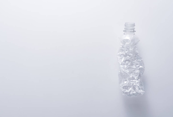 Une bouteille en plastique broyée sur fond blanc. Concept de recyclage et d'écologie. - Photo, image