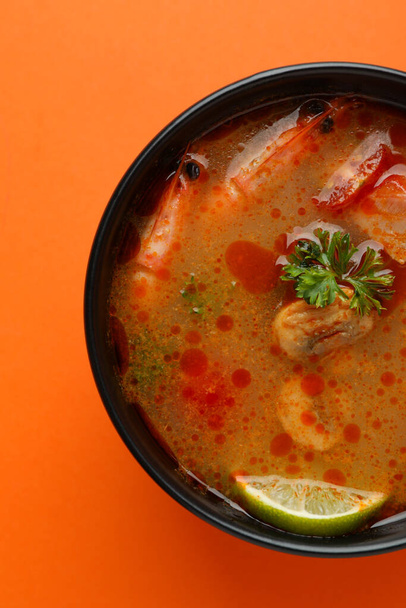 Tasty Tom yum soup on orange background - Фото, зображення