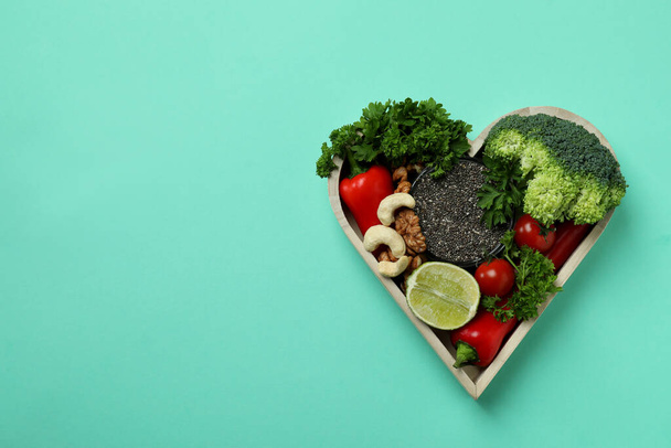 Healthy food in heart on mint background, space for text - Photo, Image