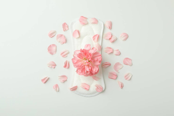 Hygiene pad with flower and petals on white background - Fotoğraf, Görsel