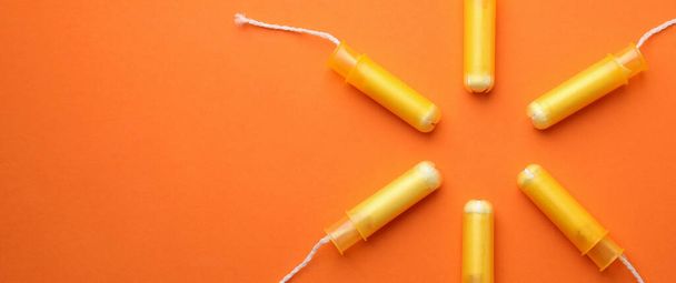 Women tampons on orange background, space for text - Foto, imagen