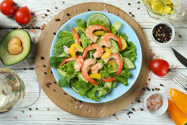Concept of tasty eating with shrimp salad on white wooden table - 写真・画像