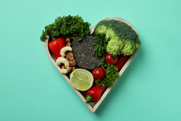 Zdrowe jedzenie w sercu na tle mięty, widok z góry - Zdjęcie, obraz