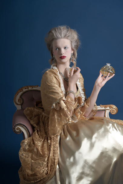 Femme de mode baroque rétro portant une robe en or. Bouteille de retenue o
 - Photo, image
