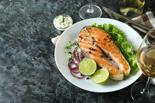 Concept of tasty eating with grilled salmon on black smokey table - Foto, Imagem
