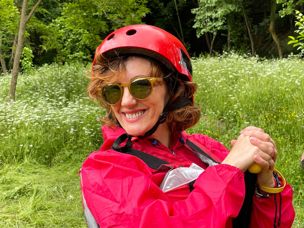 Women wearing sun glasses ready for rafting with her safety helmet . - Photo, Image