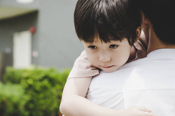 Little handsome Child hug Father during dad carry him and taking son go home after school Young boy get infect virus of flu, sick from friends at school Dad care and worry son Schoolboy get illness - Photo, Image