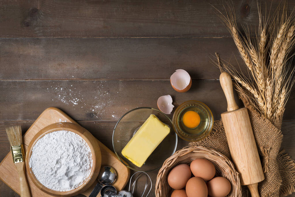 Leipäjauhot tuoretta munaa, Suolaton voi ja tarvikkeet leipomo puupohjalla, valmistautua kotitekoinen leipomo käsite - Valokuva, kuva