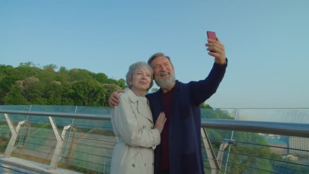 Glimlachende oude man met smartphone en selfie maken met zijn echtgenoot - Video