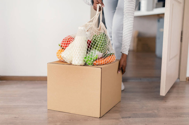 African Woman Carrying Delivered Grocery Shopping Bag And Box Indoors - Foto, Imagem