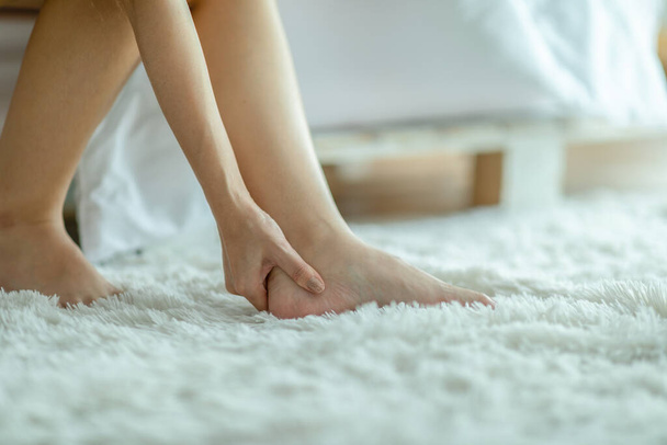 joven mujer asiática tener un tobillo dolor masaje en dolor punto, repentinamente dolorosa chica en su pie y dolor en la pierna, Salud Concepto - Foto, Imagen