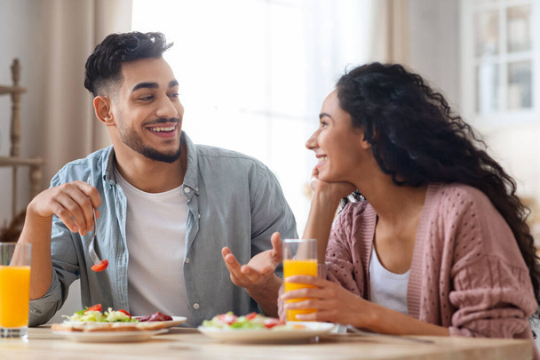 Mañana doméstica. Primer plano retrato de feliz Oriente Medio pareja comiendo desayuno juntos - Foto, Imagen