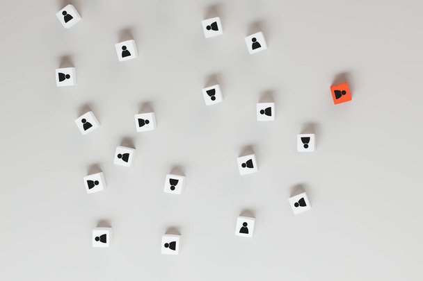Белый кубик с изображением людей, стоящих из толпы. концепция успешного руководителя команды и связи с общественностью - Фото, изображение