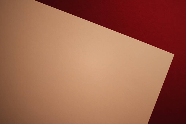 Пустая бумага формата А4, бежевый цвет на темно-красном фоне в виде офисных канцелярских принадлежностей, роскошный дизайн бренда и дизайн фирменного стиля для макета - Фото, изображение