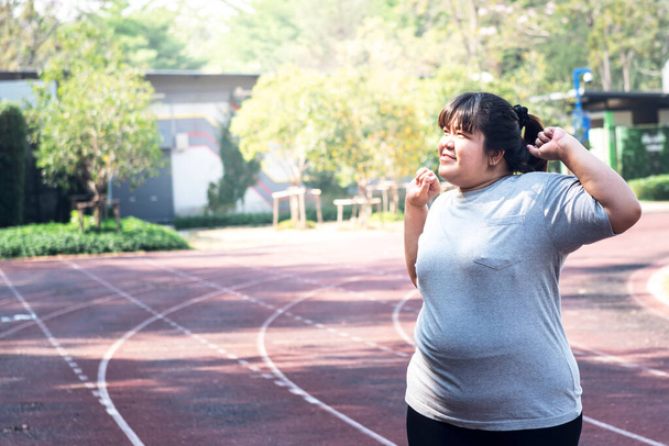 Asin mujer gorda torsión y estiramiento Para calentar el cuerpo antes del ejercicio con correr, el concepto de la gente gorda ejercicio para bajar de peso y una buena atención de la salud. - Foto, imagen