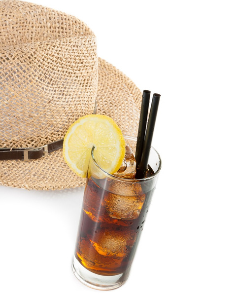 glass of fresh coke with straw in front of summer hat, summer time - Foto, Imagen