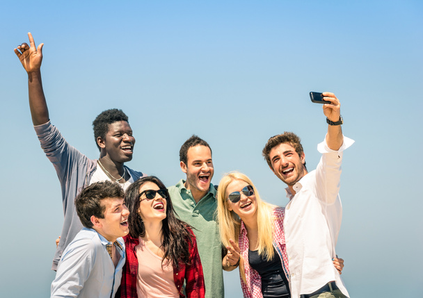Group of multiracial friends taking a selfie on the blue sky - Concept of happiness and friendship all together against racism - Zdjęcie, obraz