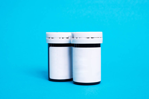 Twee potten medicijnen op een blauwe achtergrond close-up - Foto, afbeelding