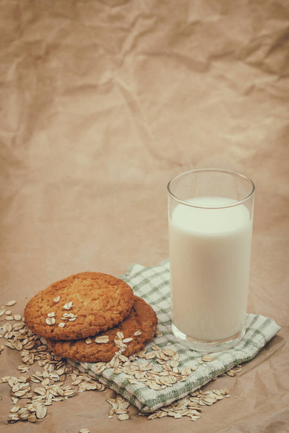 sklenice mléka a ovesných vloček sušenky na zmačkaném papíře pozadí - Fotografie, Obrázek