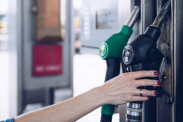 Benzin ve mazot dağıtıcısı benzin istasyonunda. Kadın arabaya yakıt ikmali yapacak.. - Fotoğraf, Görsel