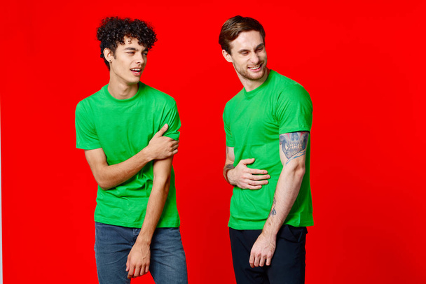 Веселые друзья в зеленых футболках коммуникационные эмоции изолированный фон - Фото, изображение