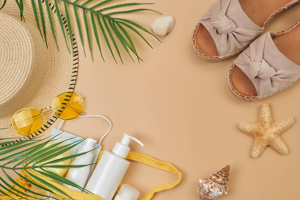 SPF sun protection cream in string bag, sunglasses, seashells and starfish, summer shoes and surgical mask on beige sand background. Summer flat lay. copy space. Trendy Sun protection accessory. - Fotografie, Obrázek