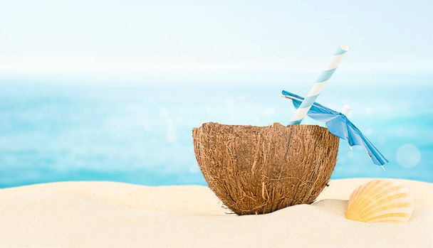 koktajl kokosowy na piasku morskim na tle morza pozbawionego ostrości - Zdjęcie, obraz