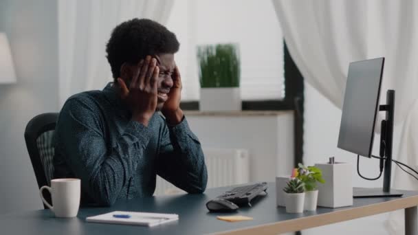 Stressaava afrikkalainen amerikkalainen mies, jolla on suuri päänsärky kipu, joka kärsii migreenistä, hieroo temppeleitään - Materiaali, video