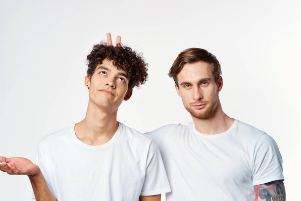 Beyaz tişörtlü iki adam elleriyle Dostluk Stüdyosu 'nu işaret ediyor. - Fotoğraf, Görsel