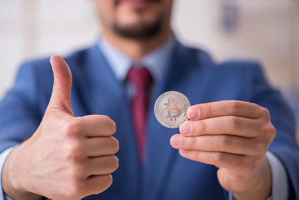 Young man earning money via Internet in cryptocurrency concept - Photo, Image