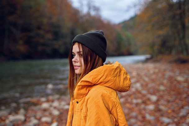 жінка гуляє в осінньому лісі в жовтій куртці гори подорожують
 - Фото, зображення