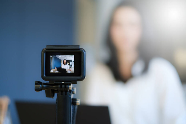 Business woman or blogger recording vlog on digital camera and live stream. - 写真・画像