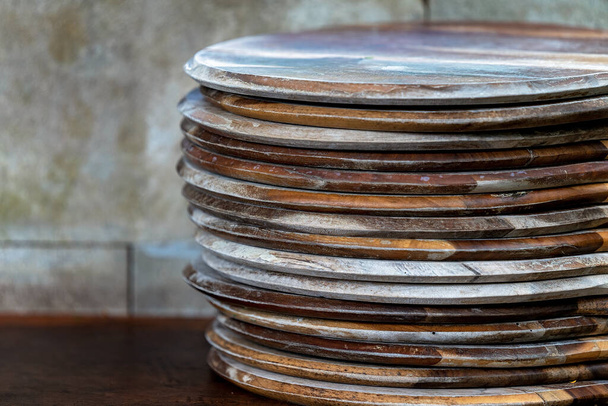 Una pila de bandejas de pizza en un banco listo para la comida del horno - Foto, Imagen